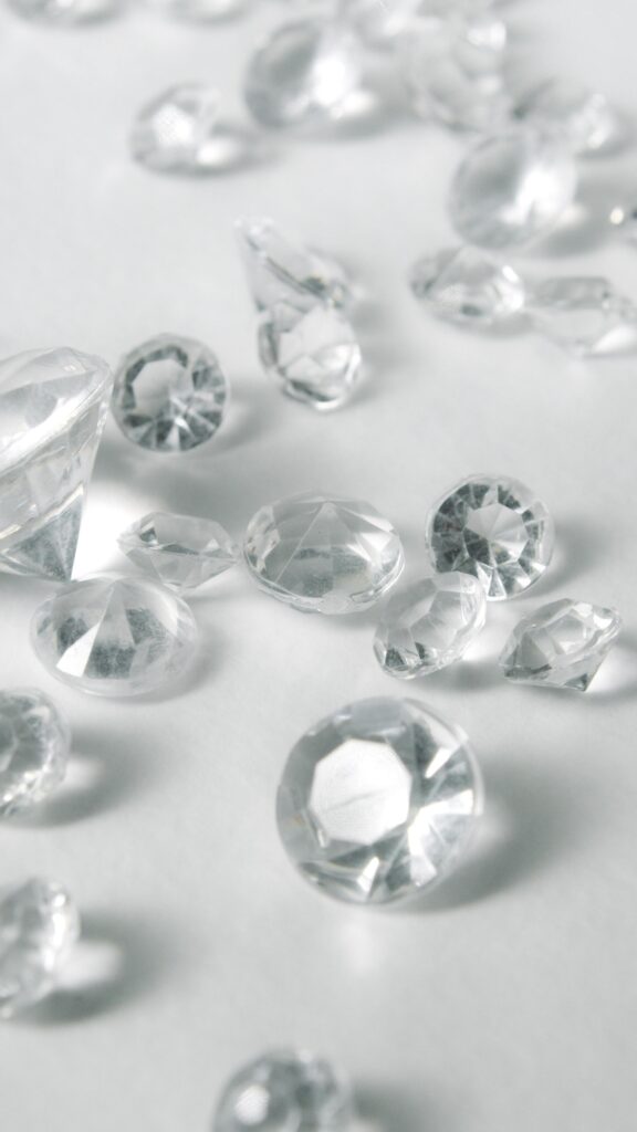 A close-up of various clear-cut gemstones on a white surface, showcasing their sparkle and clarity.