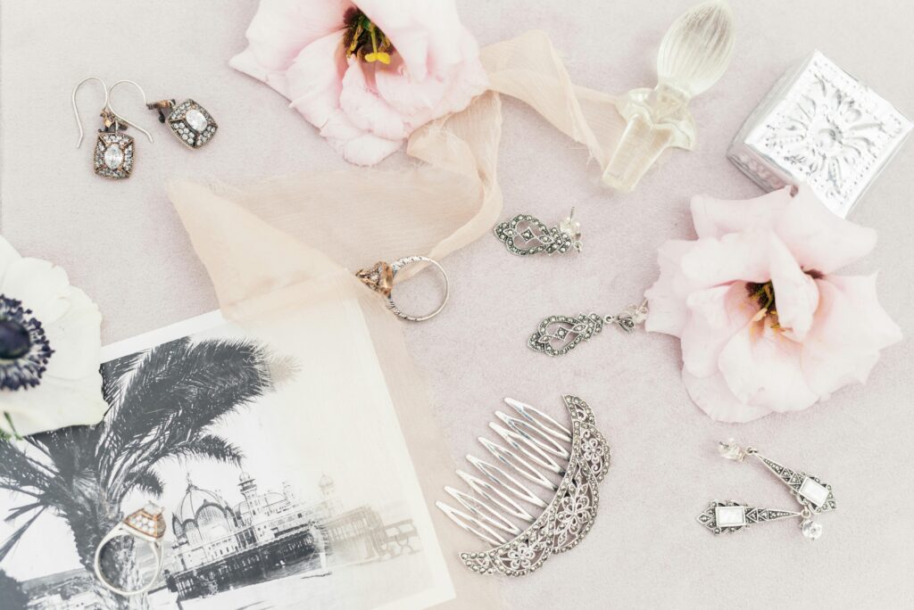 A delicate assortment of vintage jewelry and flowers in a flat lay composition.